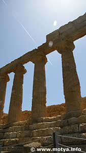 The columns of the temple of Juno against the sky with a passing airplane The columns of the temple of Juno against the sky with a passing airplane