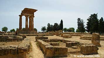 The sacred area of the divinities of the underground, several altars of round and rectangular form are still present. In the background the temple of the Dioscuri. The sacred area of the divinities of the underground, several altars of round and rectangular form are still present. In the background the temple of the Dioscuri.